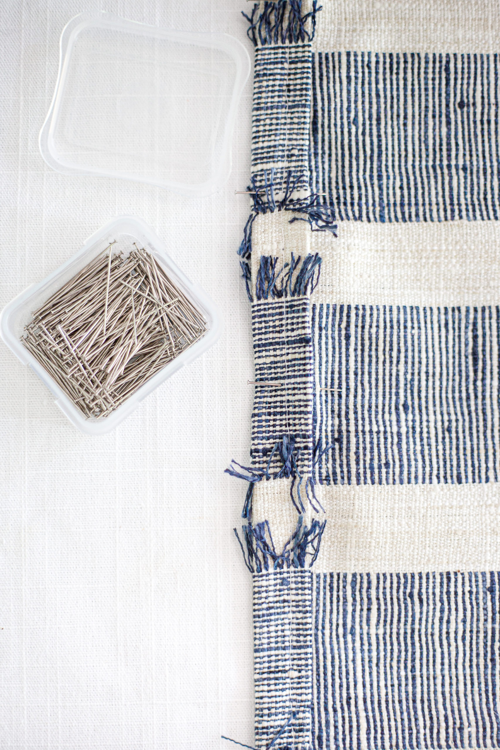 Pinning the seam of the blue and white stripe fabric for Envelope Pillow Cover Tutorial 