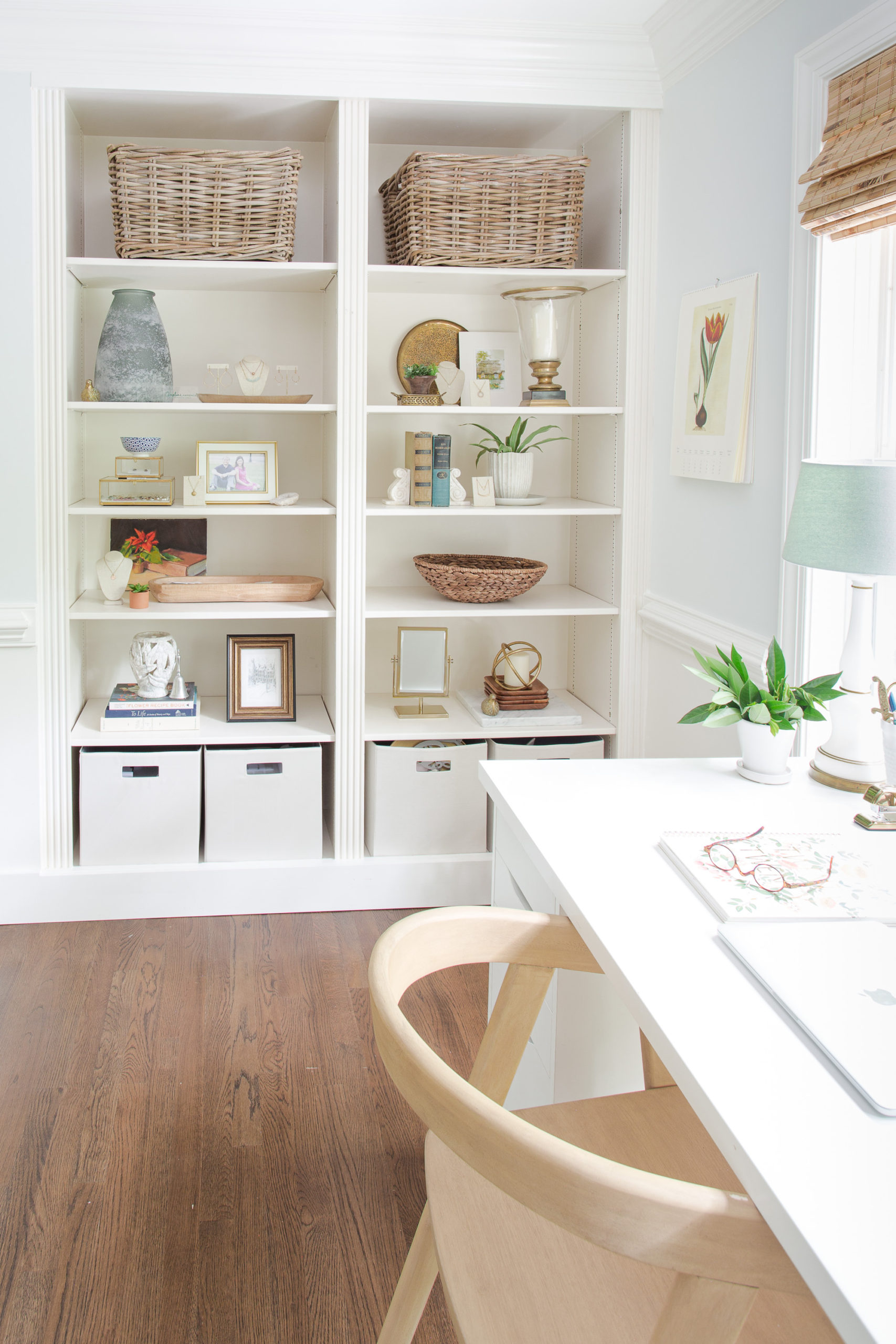 Built-in bookcases in home office with decor and baskets. 
