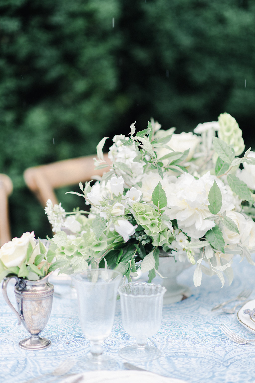 white and green floral centerpiece on table with glassware