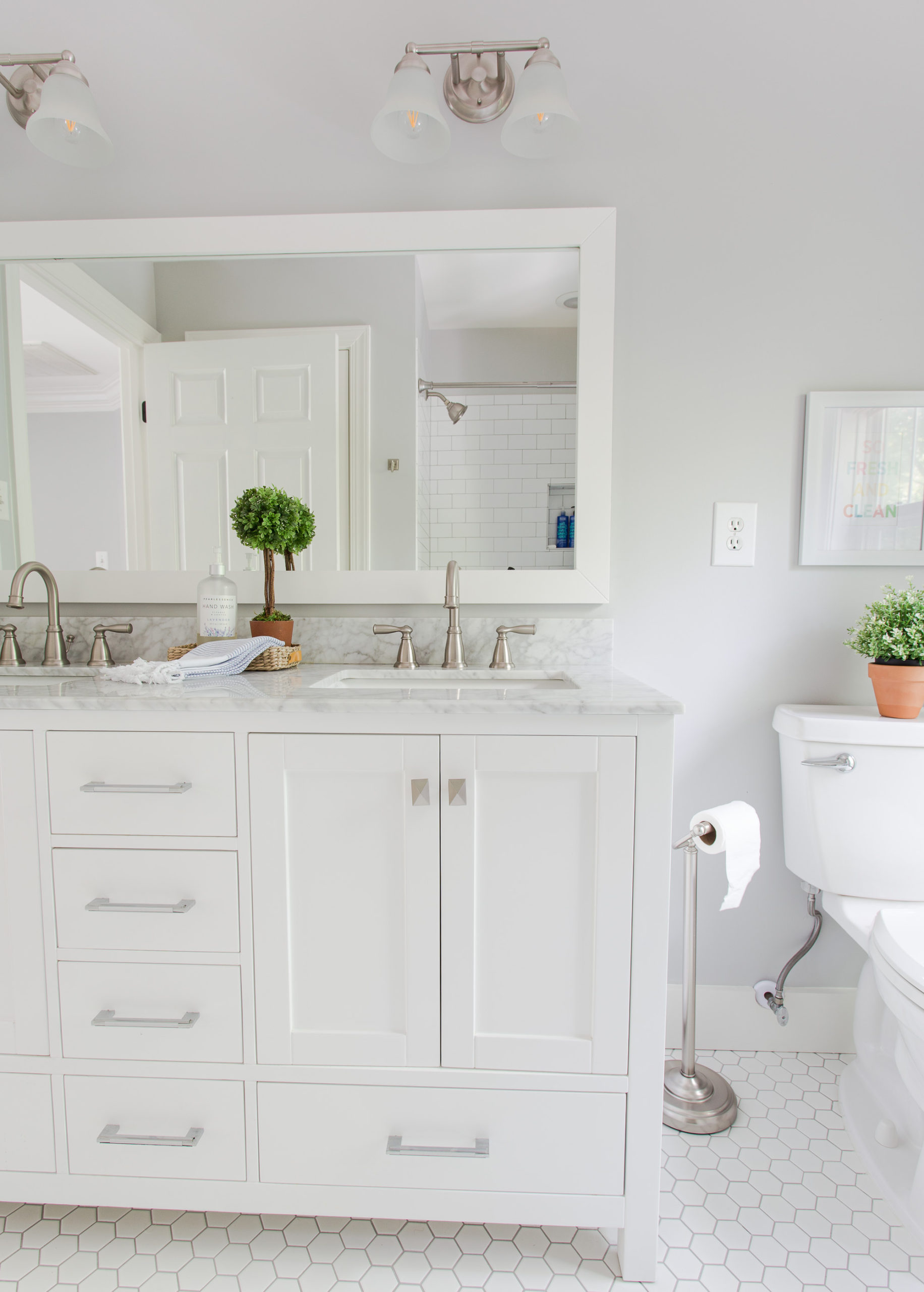 Bathroom remodel with white cabinet, marble countertops and hexagon floor tile