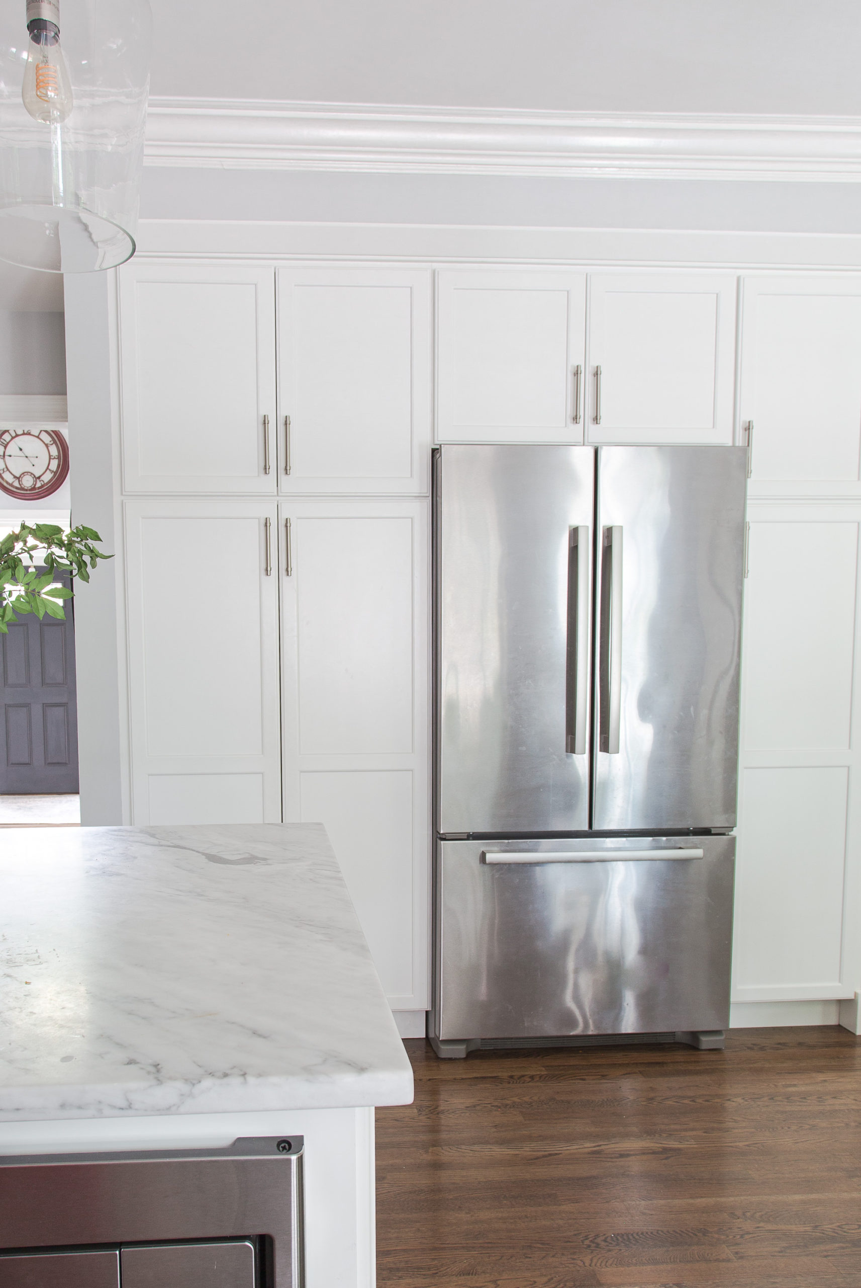 white kitchen pantry cabinets with stainless steel fridge