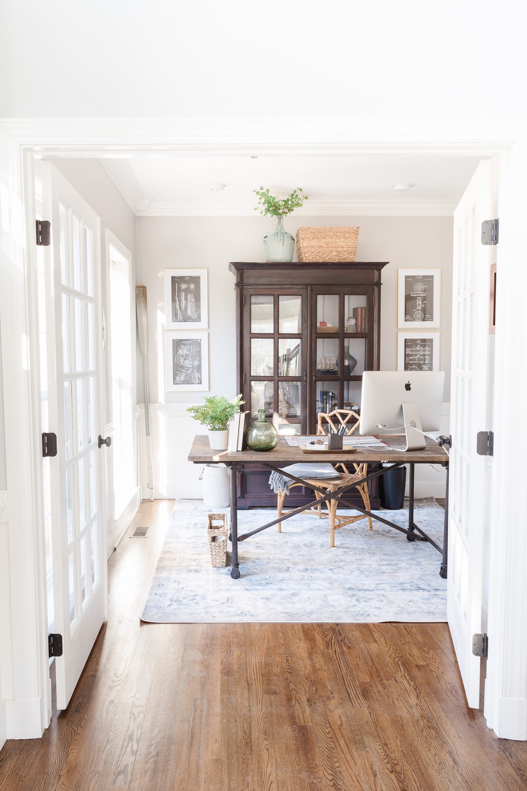 Home office with large armoire, desk and artwork on each side of armoire