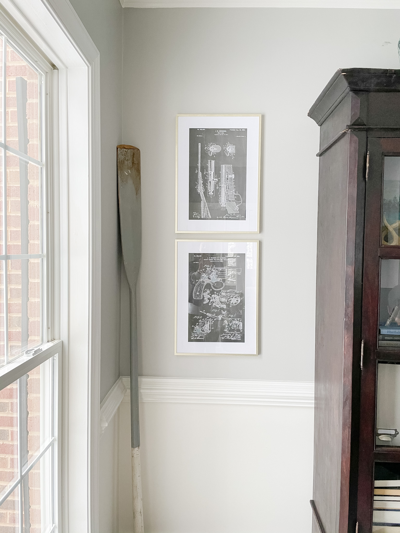 Two blue print sketches in gold frames hanging on the wall