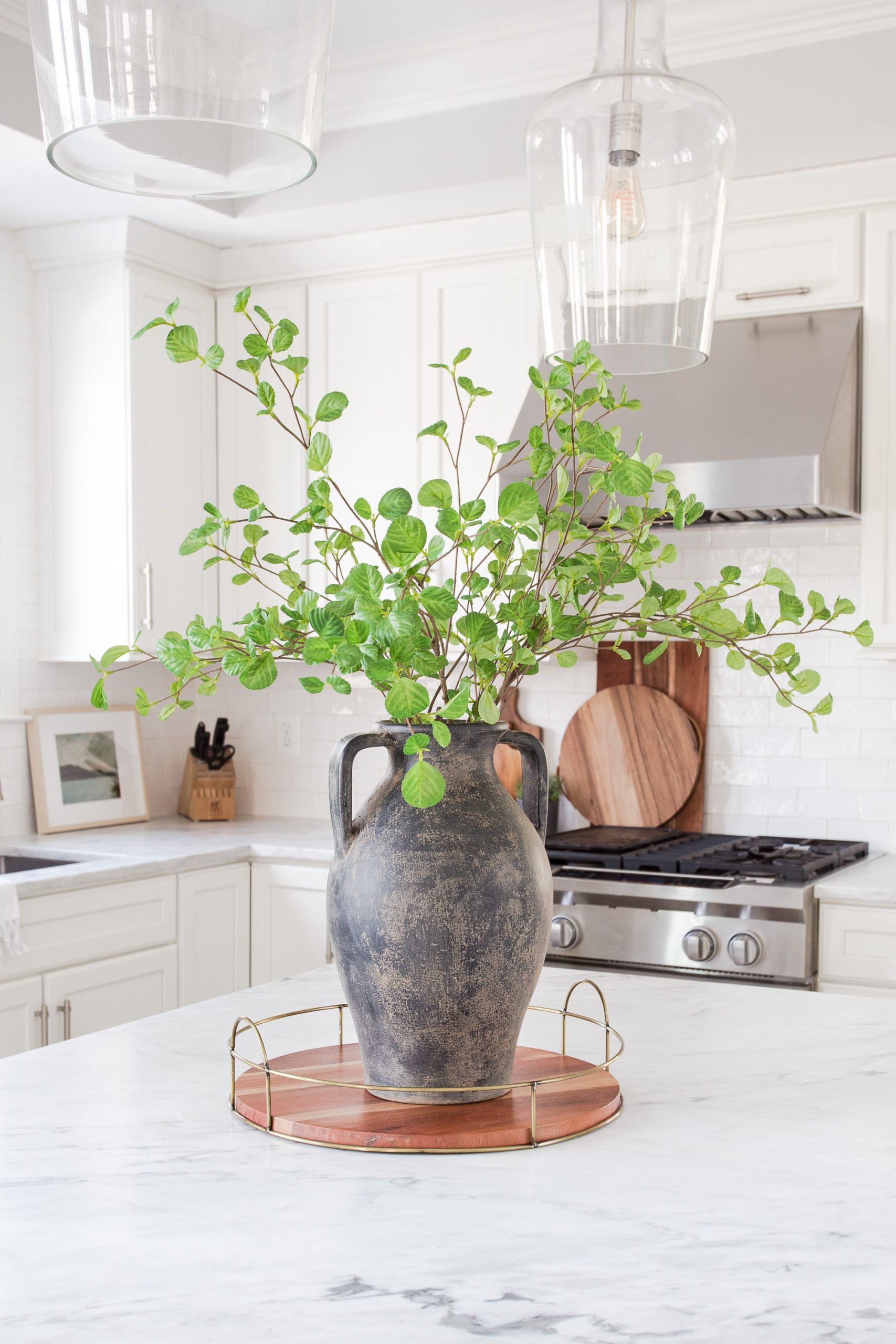 black vintage vase with greenery sitting on kitchen marble countertop