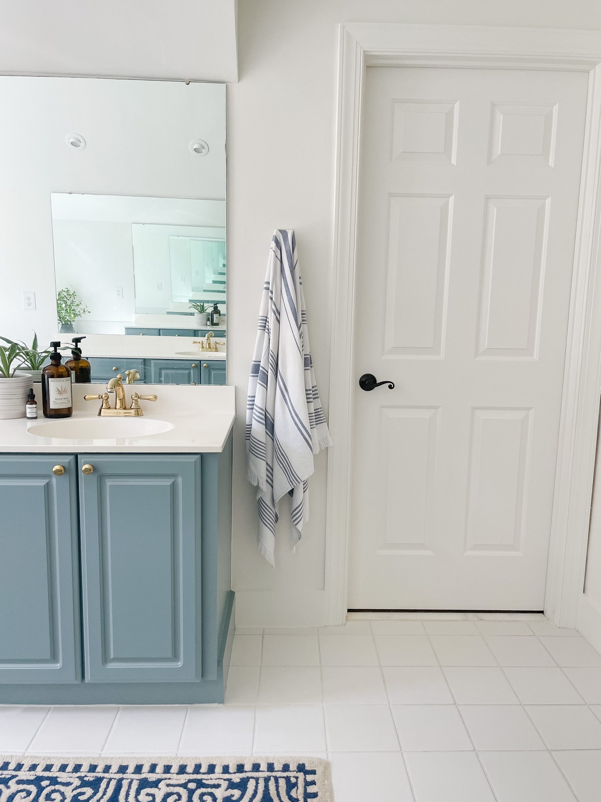 Blue Painted Bathroom Cabinet in a white bathroom with pvc trim baseboards