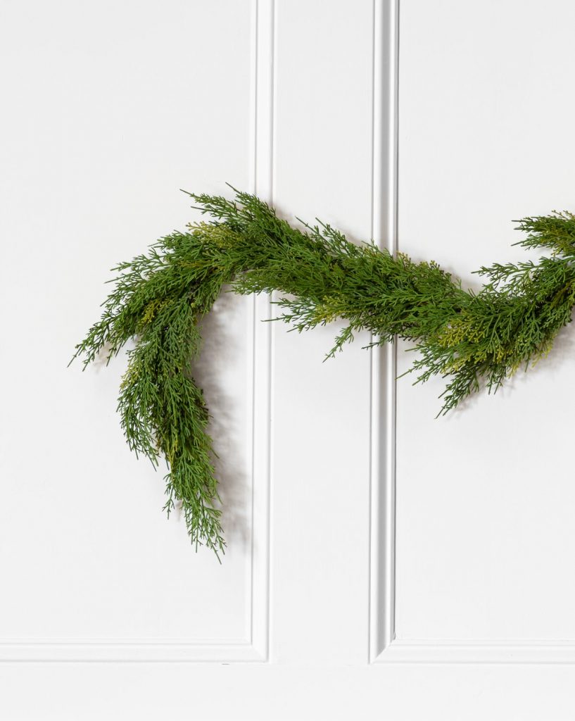 green garland draped on white wall with trim