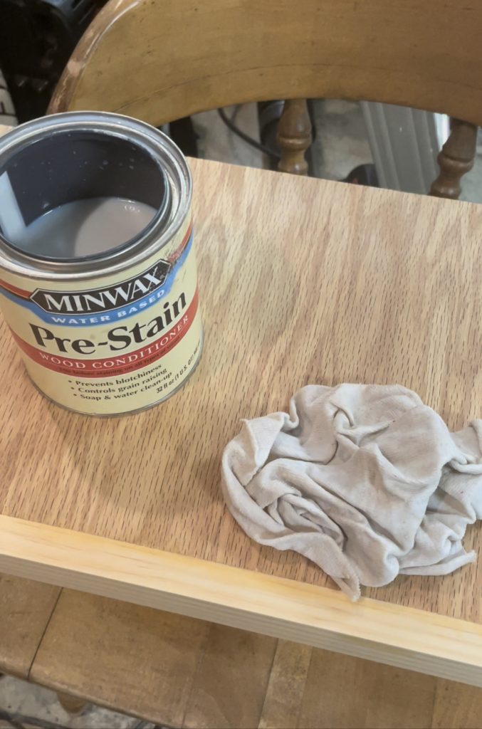 can of pre-stain and rag sitting on shelf