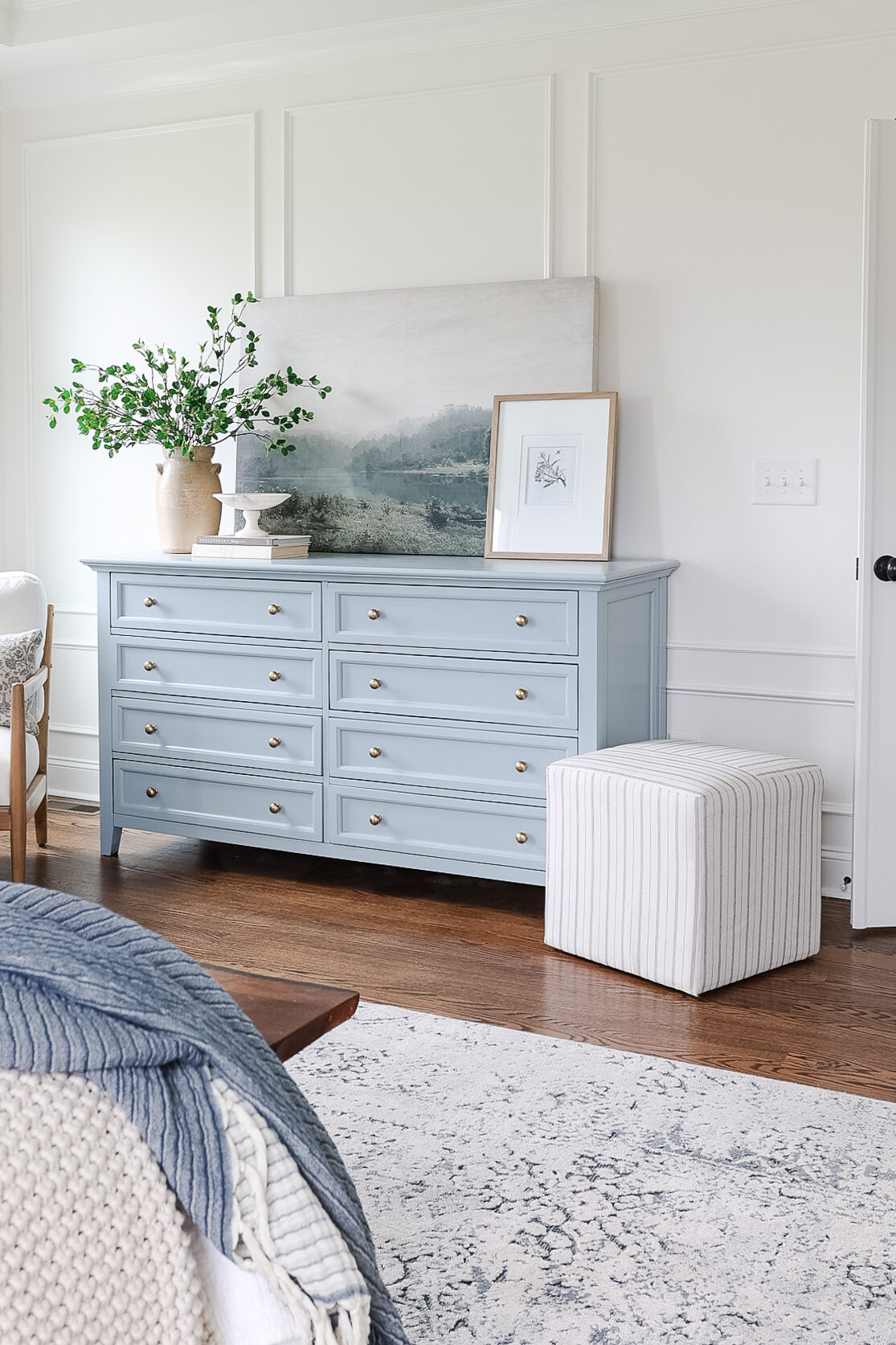 sherwin williams stardew blue dresser in bedroom with art and vase of greenery