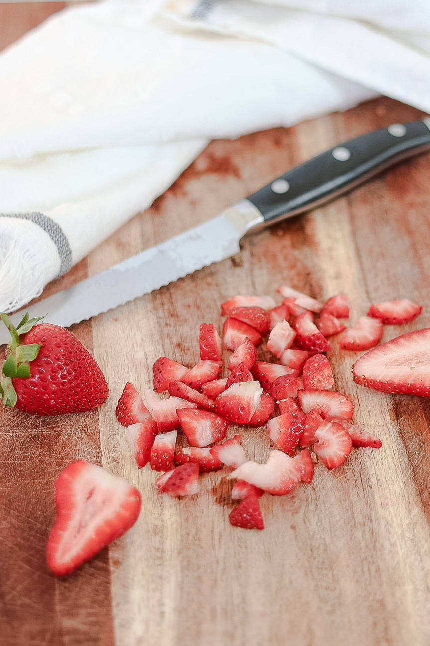 diced strawberries on a wood cutting board