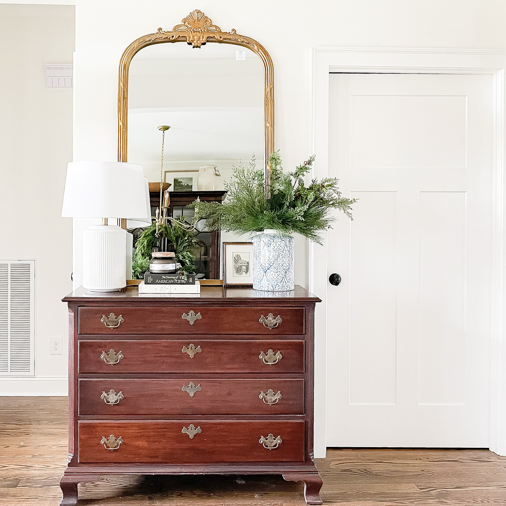 Mahogany dresser with mirror and lamp in hallway