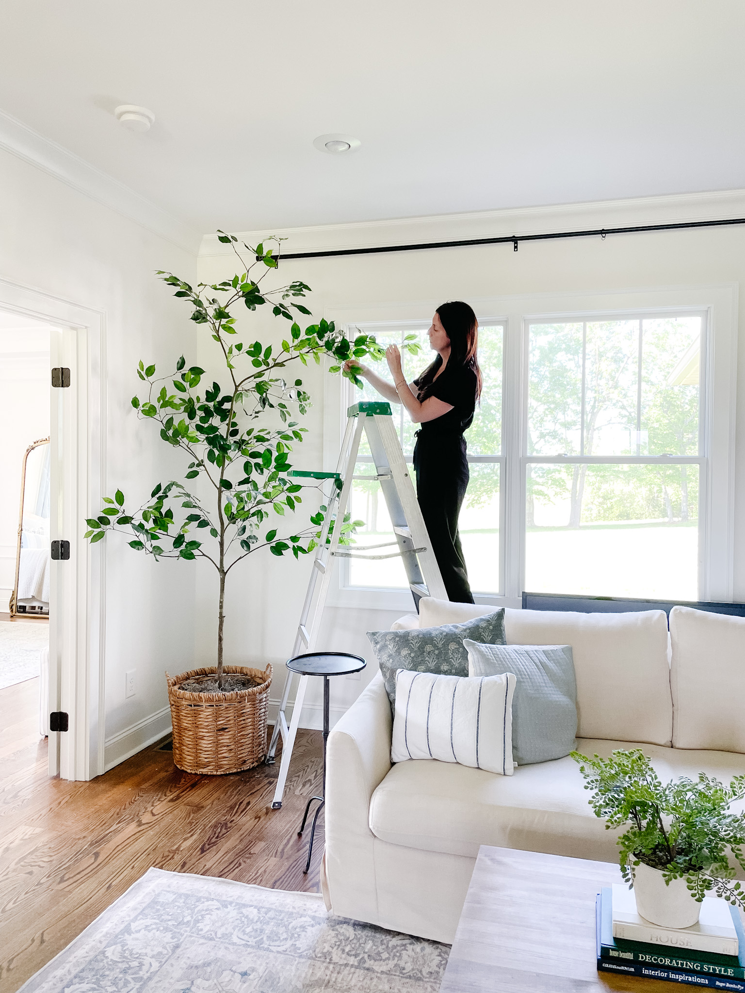 living room with lady assembling a fake tree