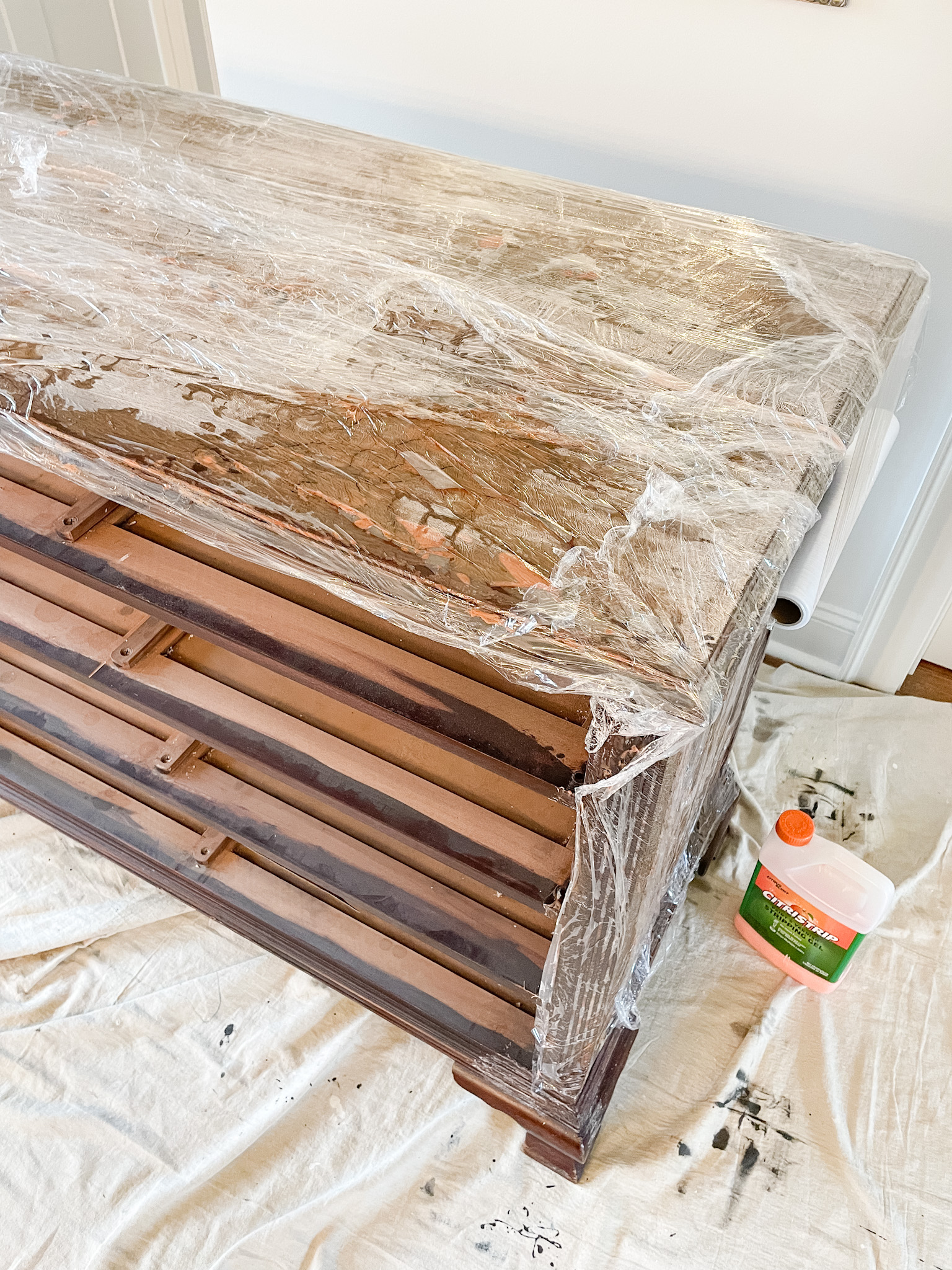 dresser wrapped in plastic wrap for stripping