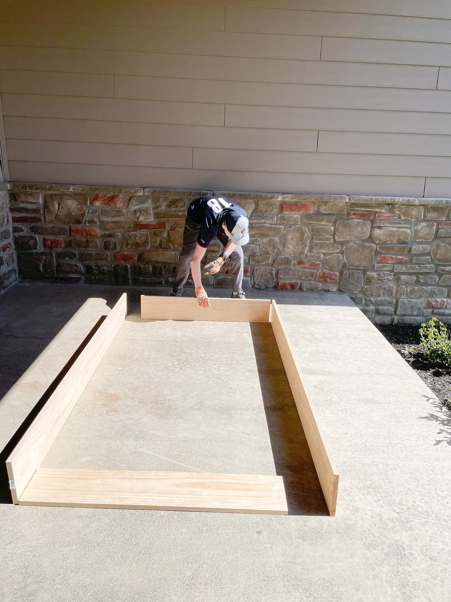 boy putting together base of patio swing