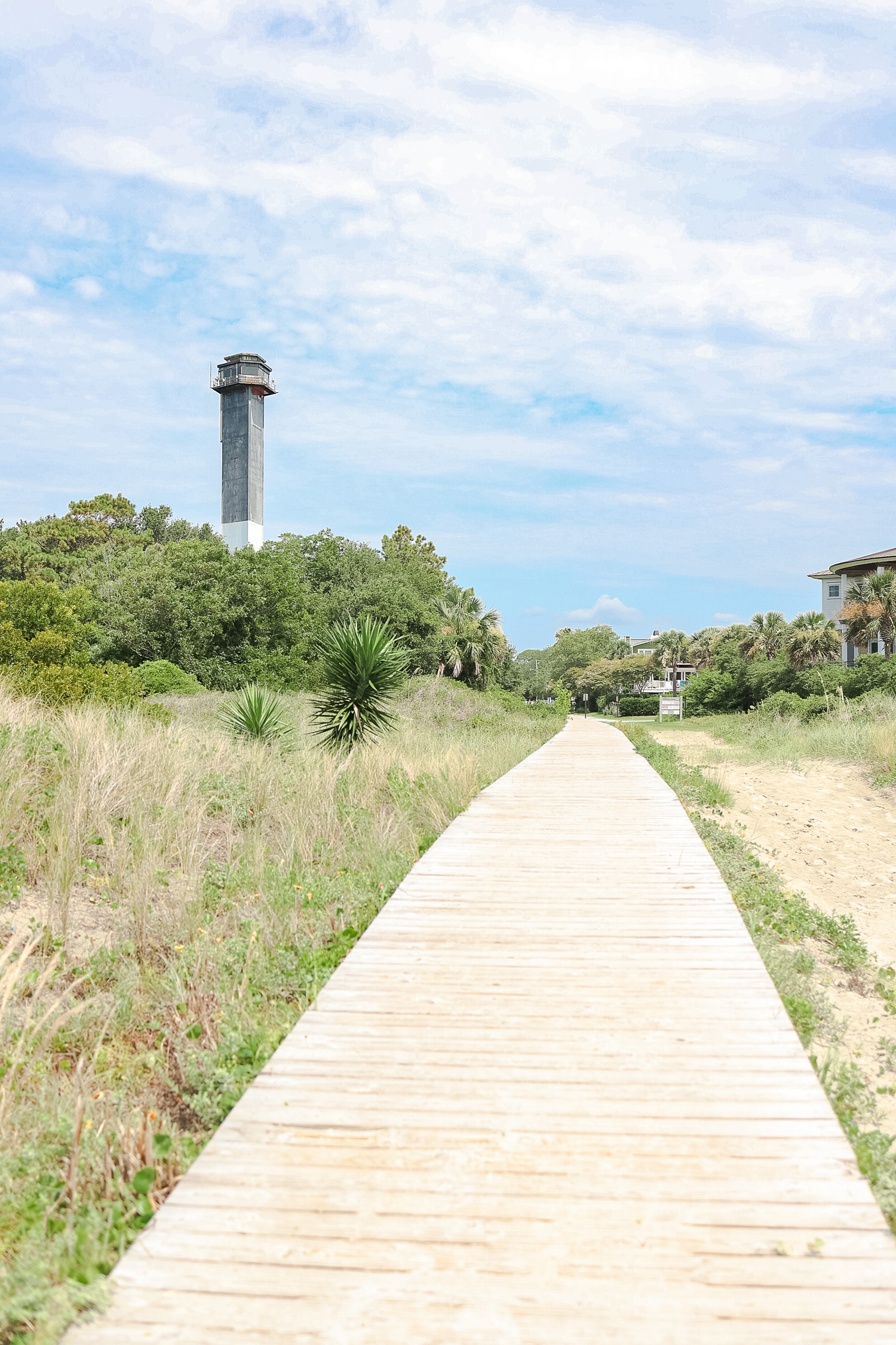 Beach boardwalk with lighthouse