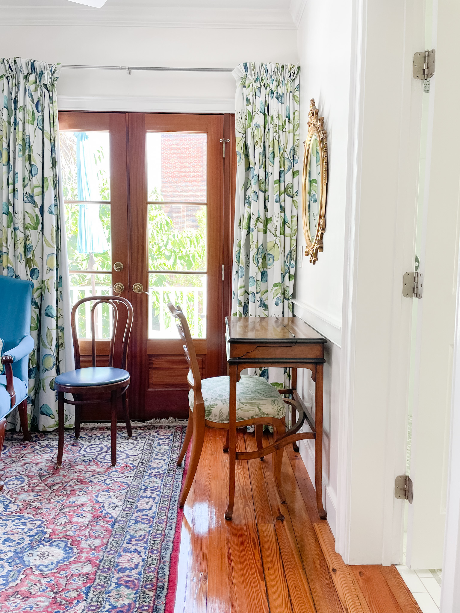 Desk and chair with rug next to door
