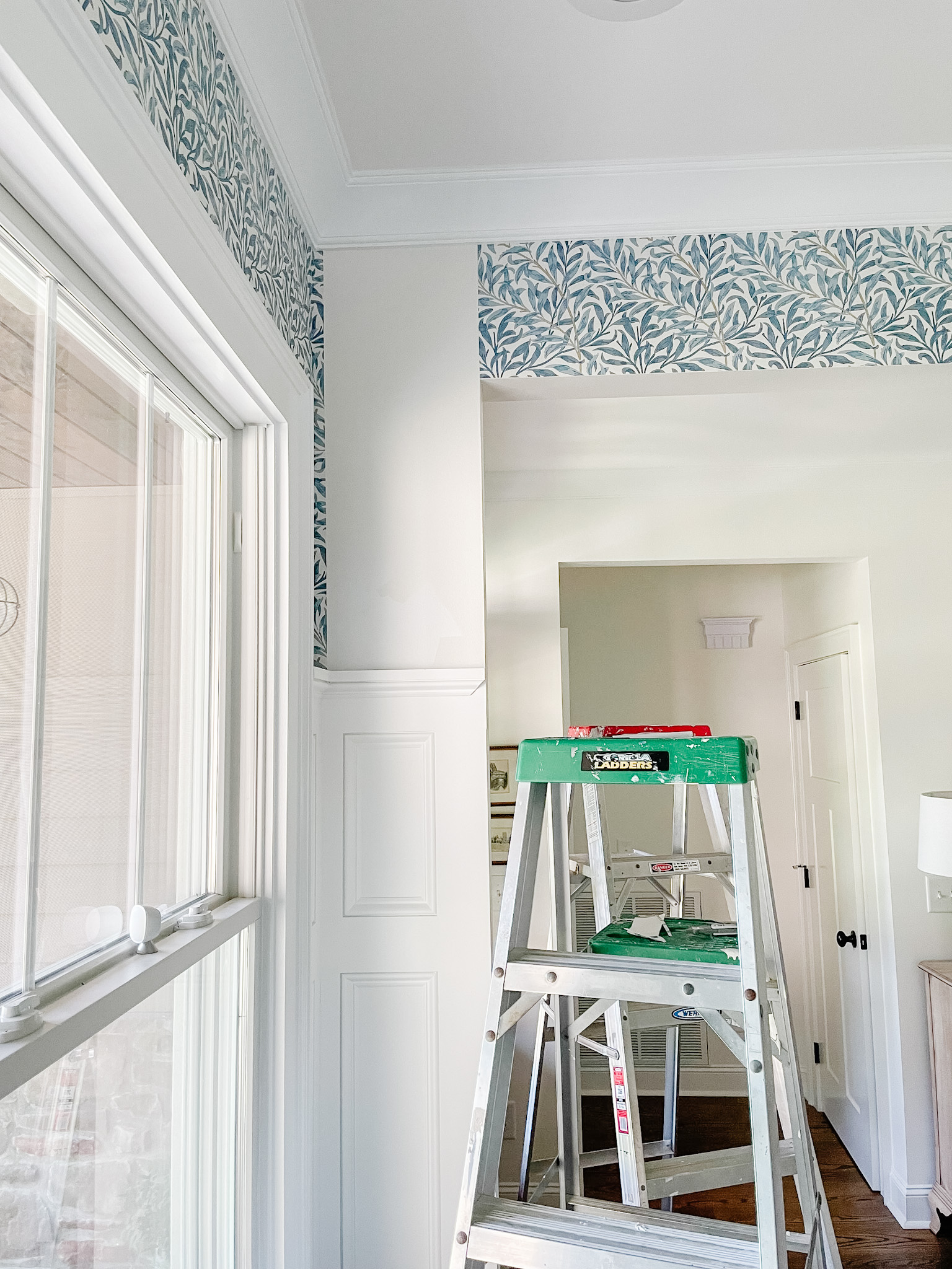 hanging wallpaper with ladder in room
installing wallpaper