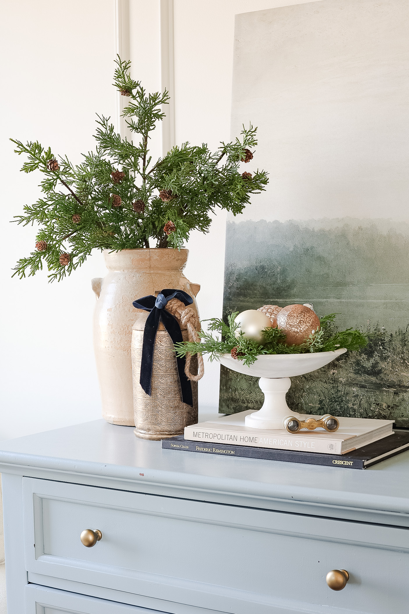 christmas bedroom decor on the dress. Vase of greenery and bowl of ornaments