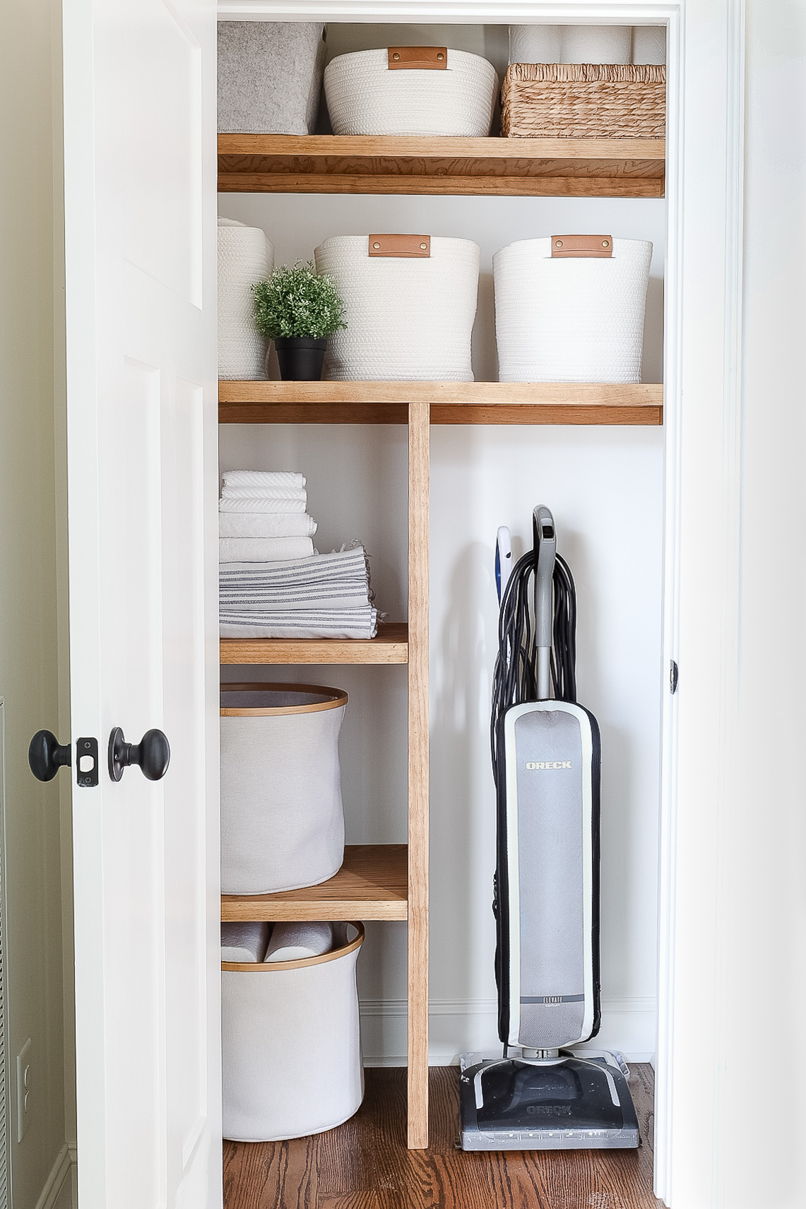 hall closet with vacuum and storage supplies