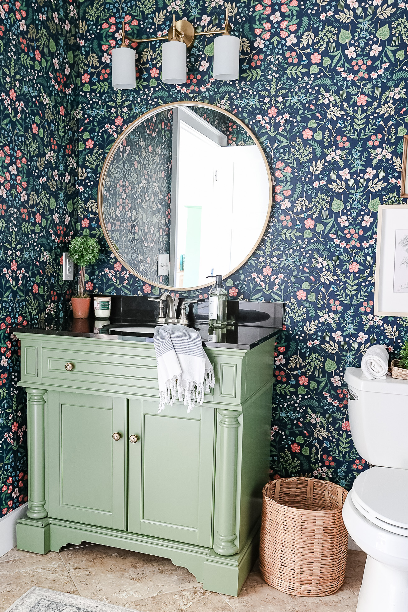 installing wallpaper in bathroom with green vanity