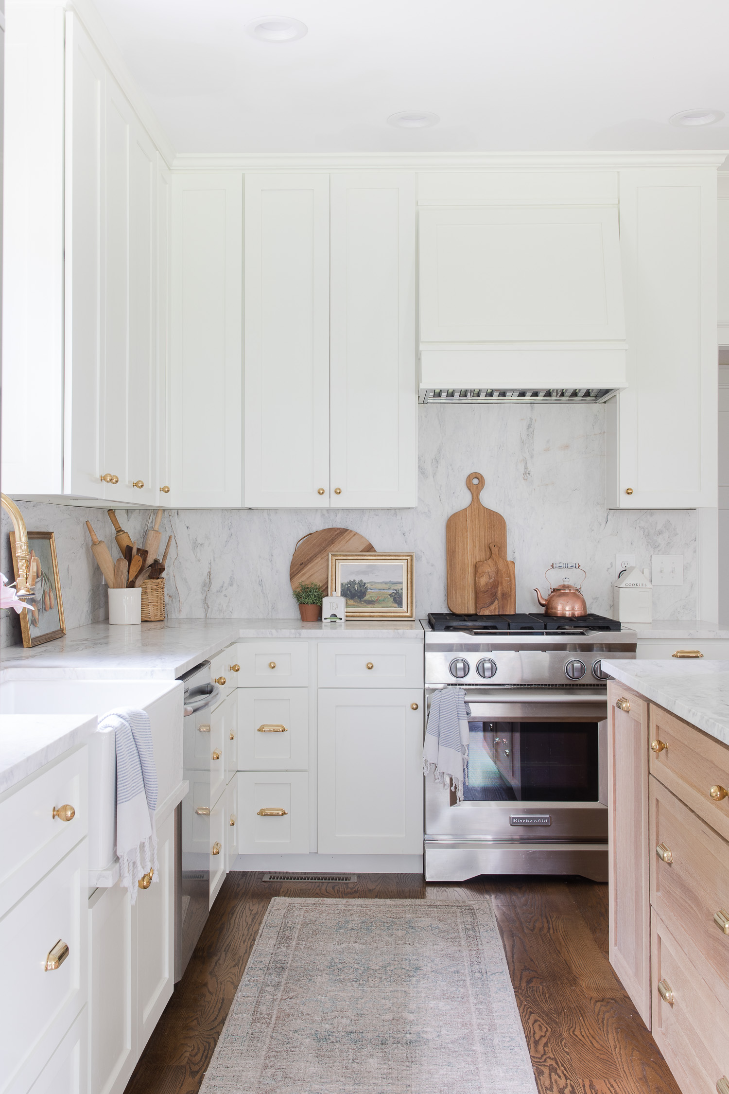 white kitchen with wood island and runner rug on the floor