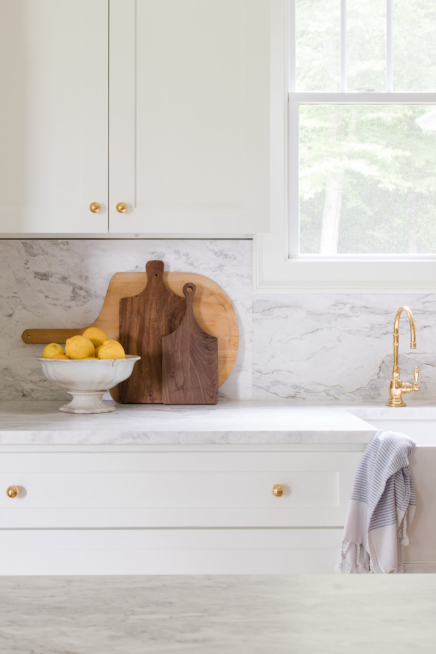 marble kitchen backsplash and cutting boards with bowl of lemons