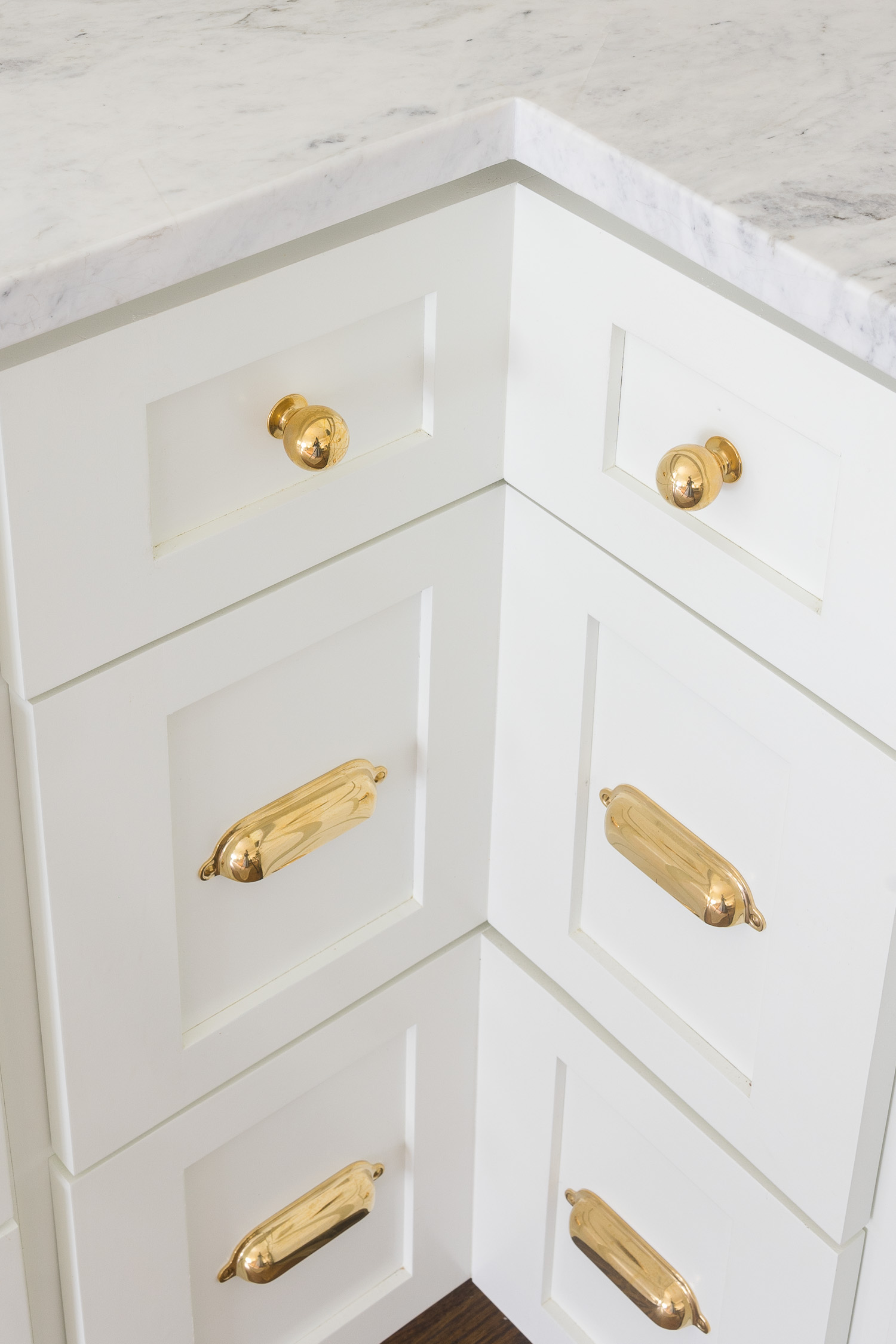 white kitchen cabinets with unlacquered brass hardware