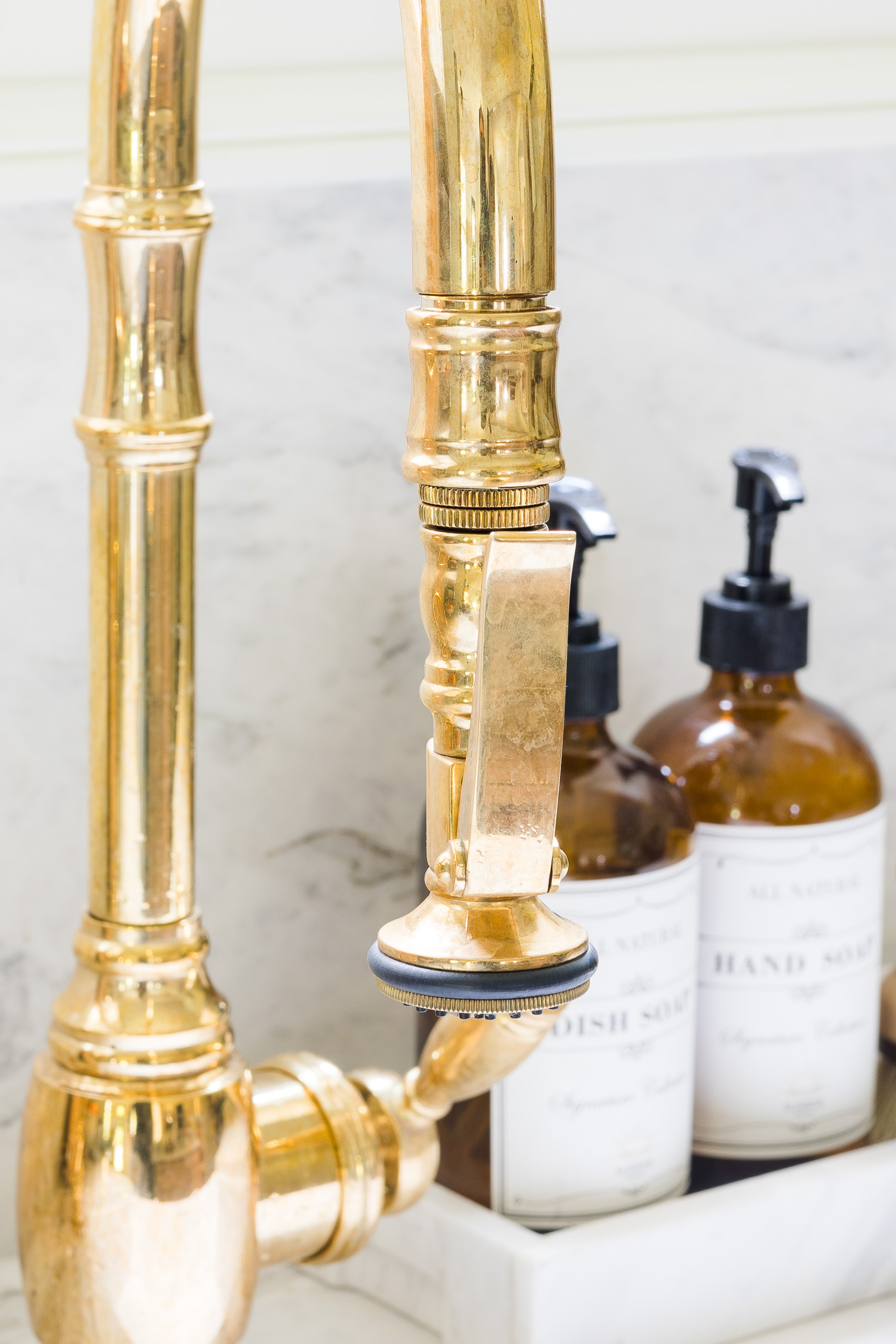 unlacquered brass kitchen faucet and sink in kitchen