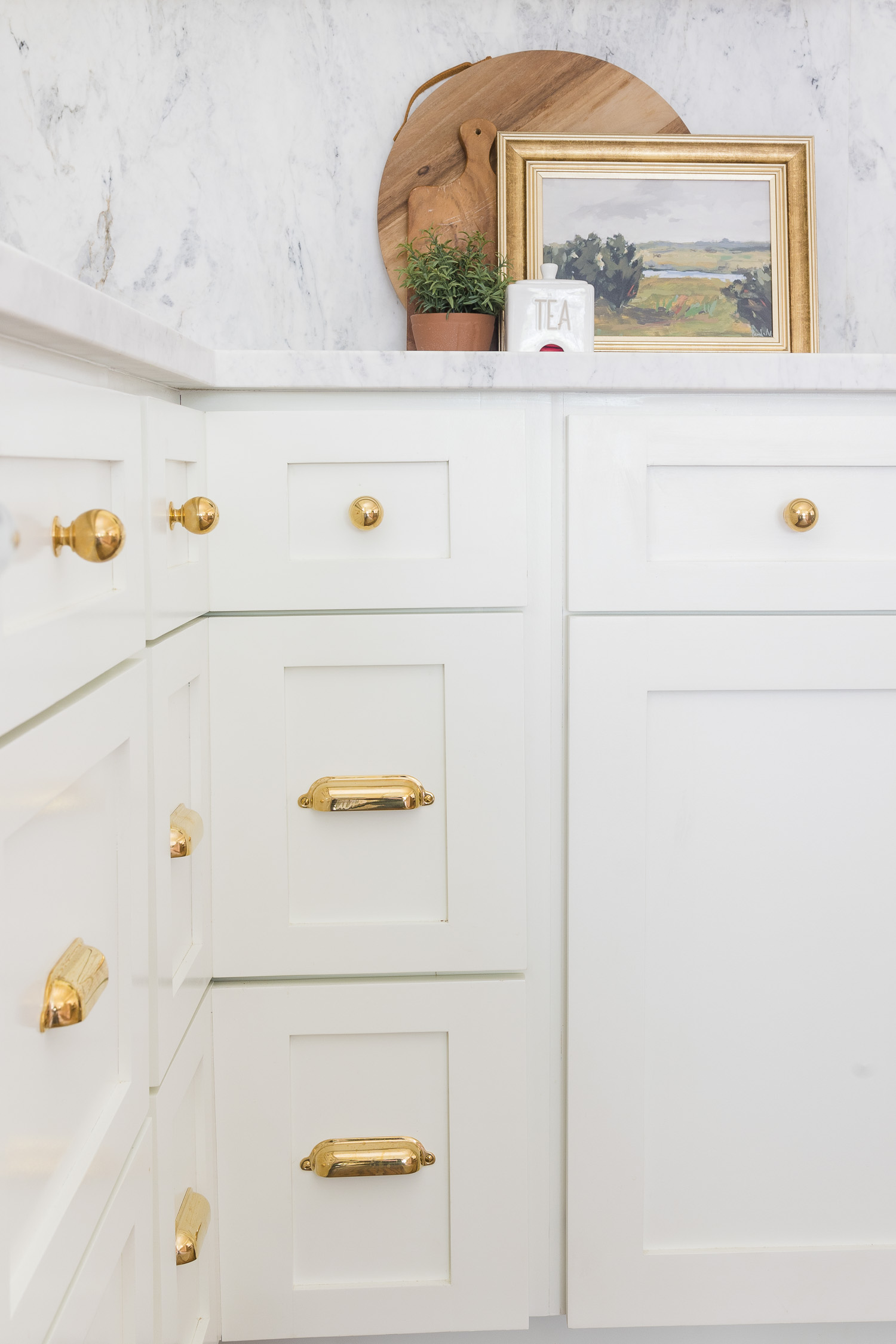 white kitchen cabinets with unlacquered brass hardware