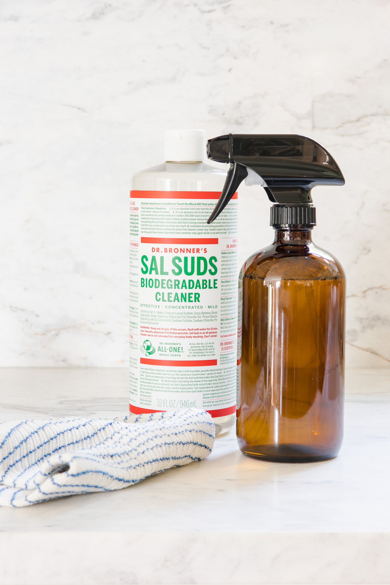 amber glass spray bottle with bottle of sal suds sitting on countertop to make all purpose cleaner