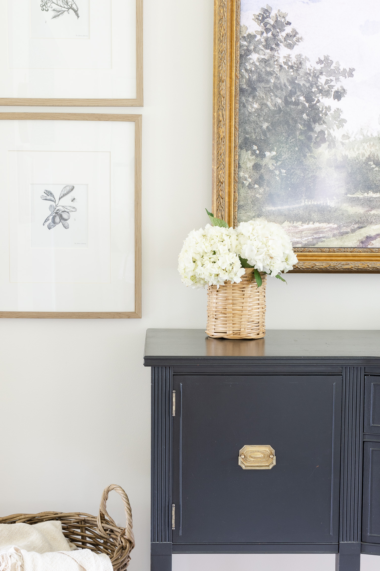 white hydrangea in basket on black buffet cabinet