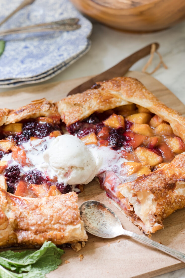 peach blackberry galette with ice cream on cutting board