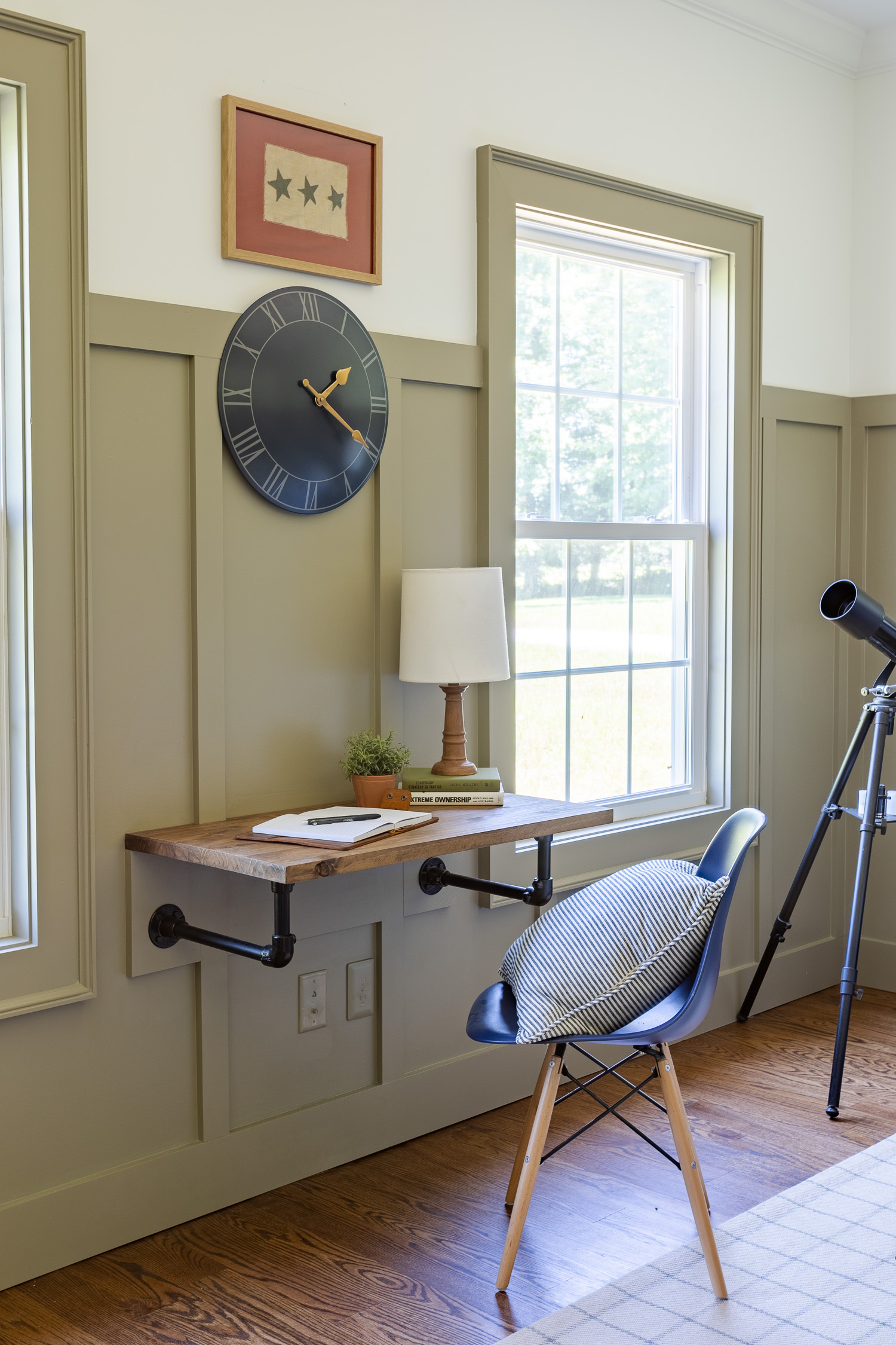 wood and pipe desk next to window in boys bedroom