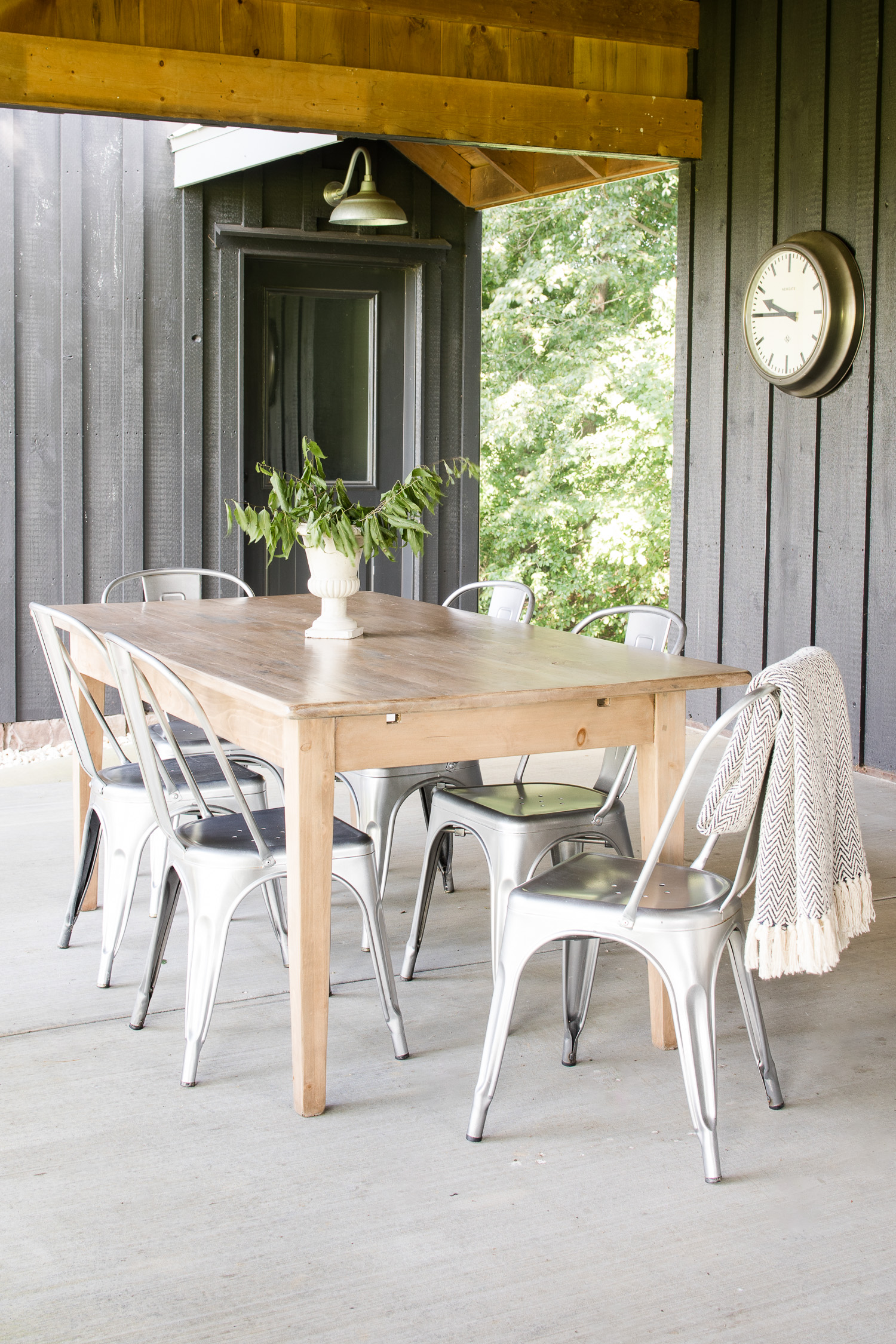 black barndominium with light wood table, silver chairs