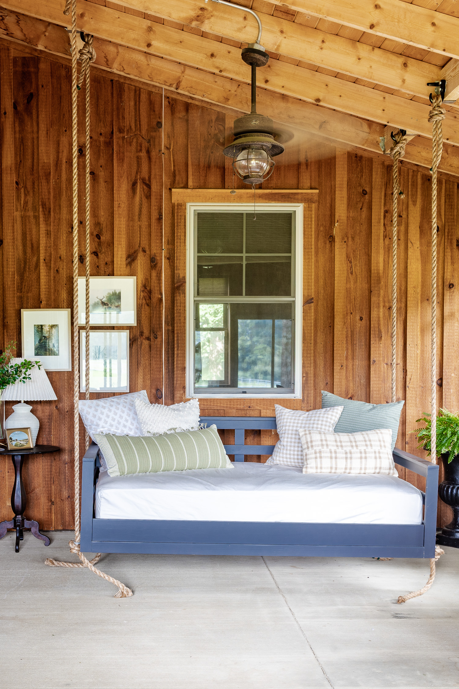 barndominium patio with hanging swing and throw pillows and artwork