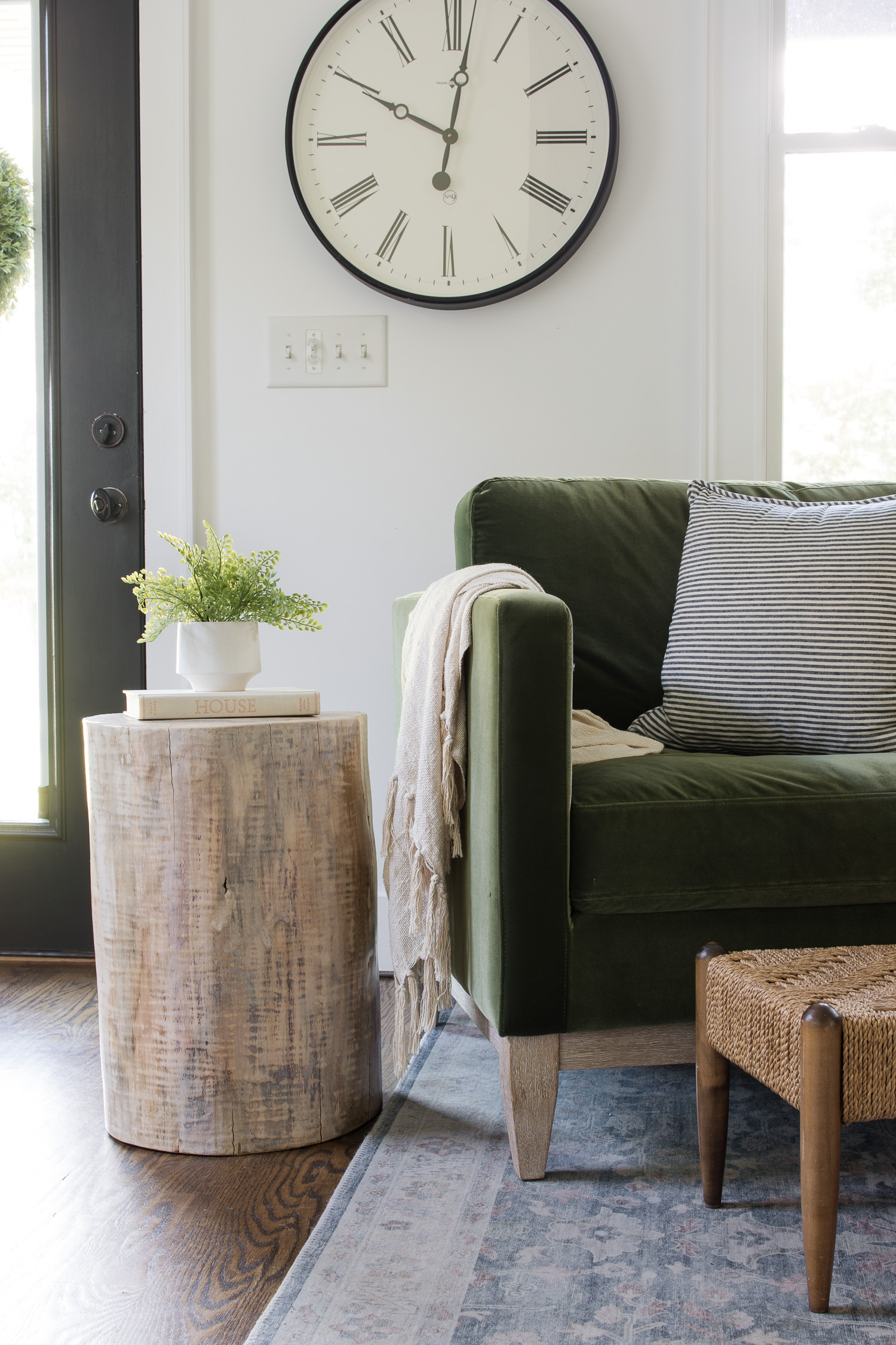tree stump table sitting in living room next to green velvet chair