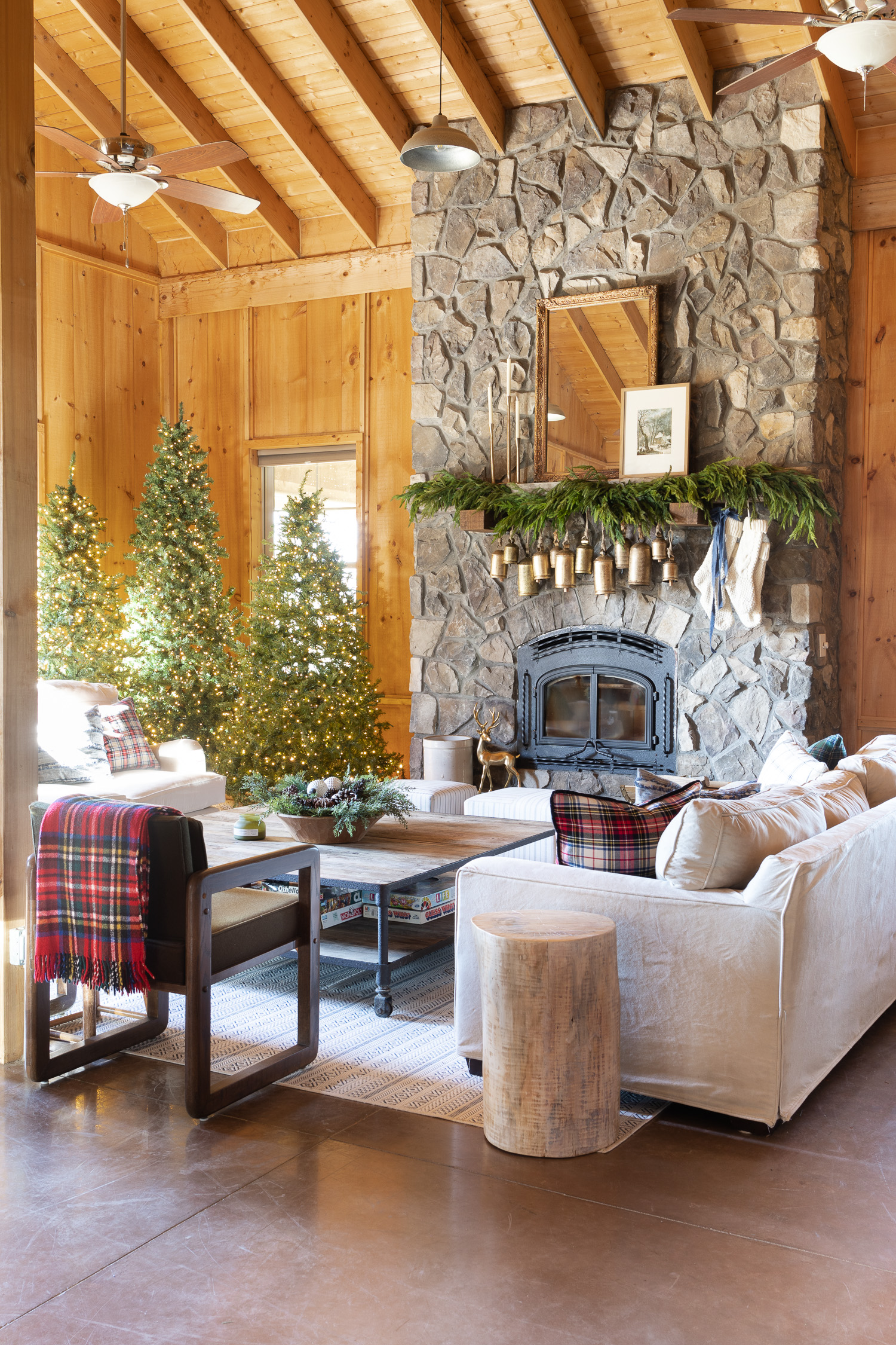 log cabin stone fireplace with brass bells hanging down from mantle