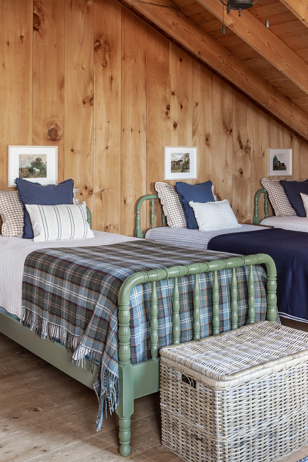 barndominium bedroom with green spindle beds with plaid wool blanket