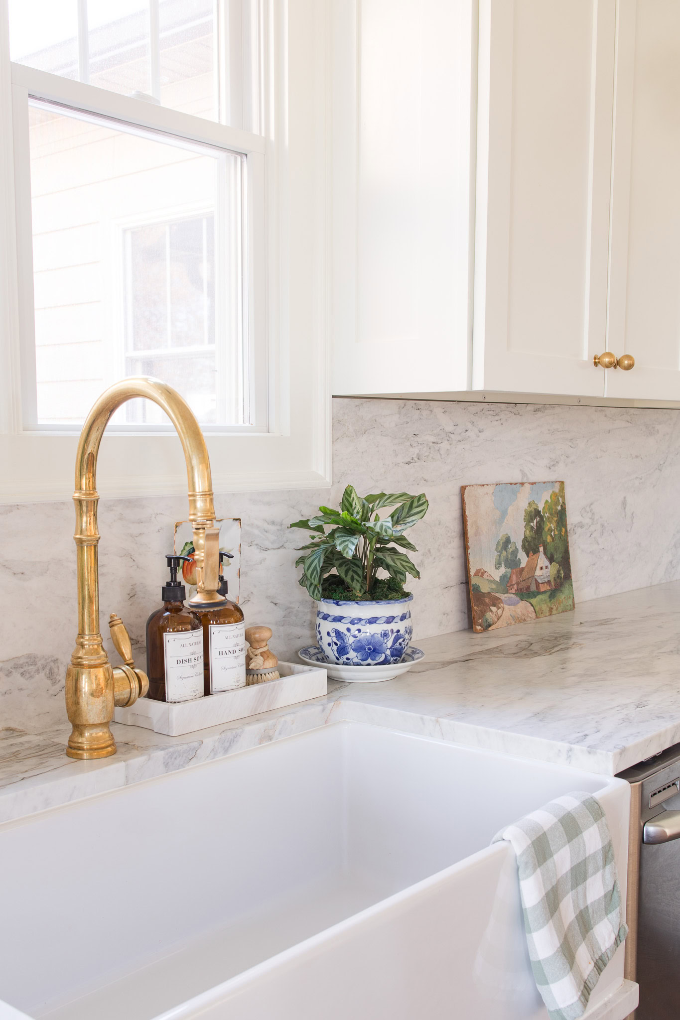 brass faucet at sink with marble countertop surround