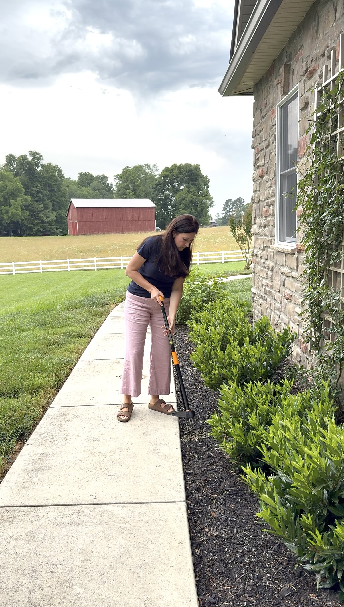lady weeding her yard with garden tool