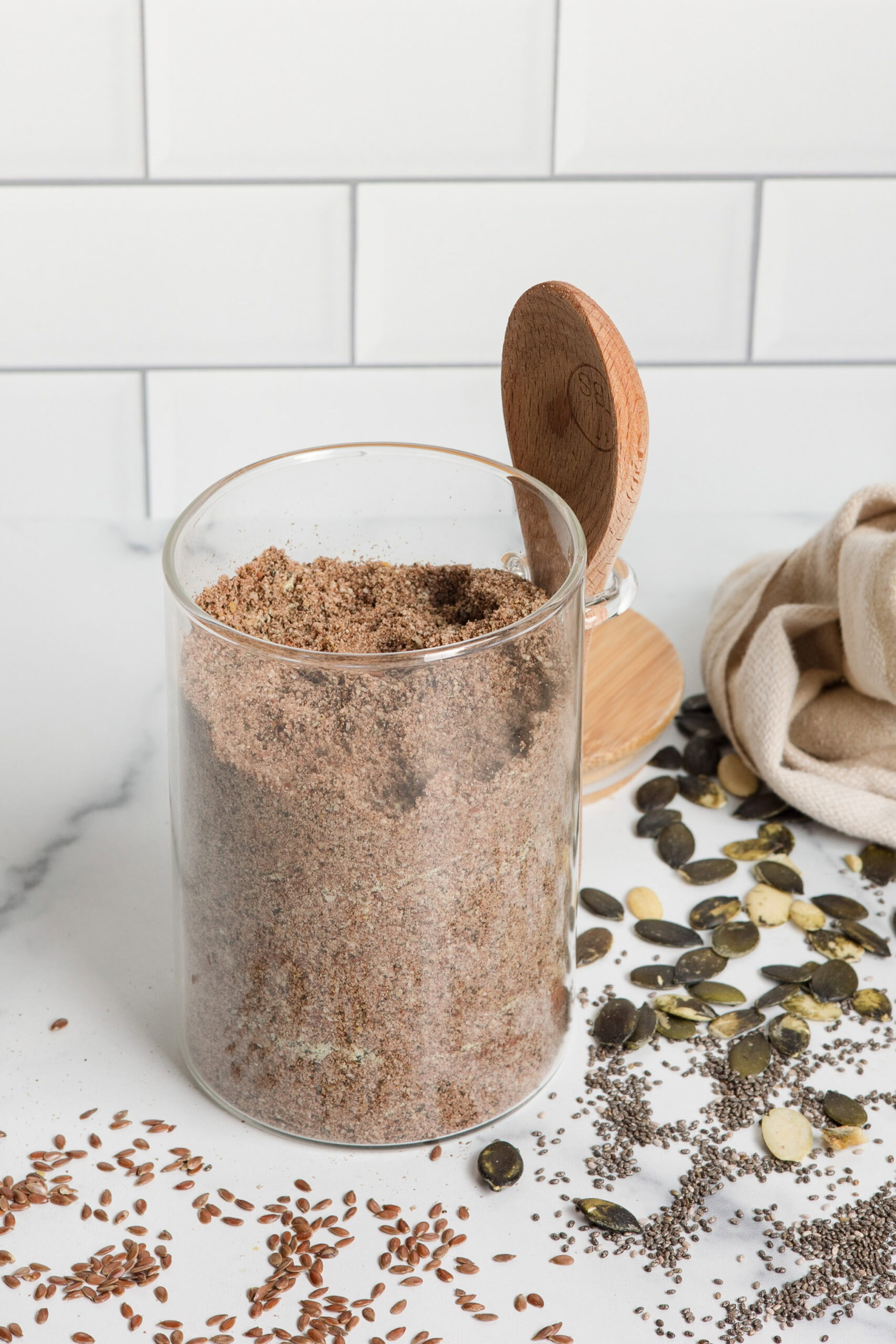 glass jar of homemade protein powder with wood spoon