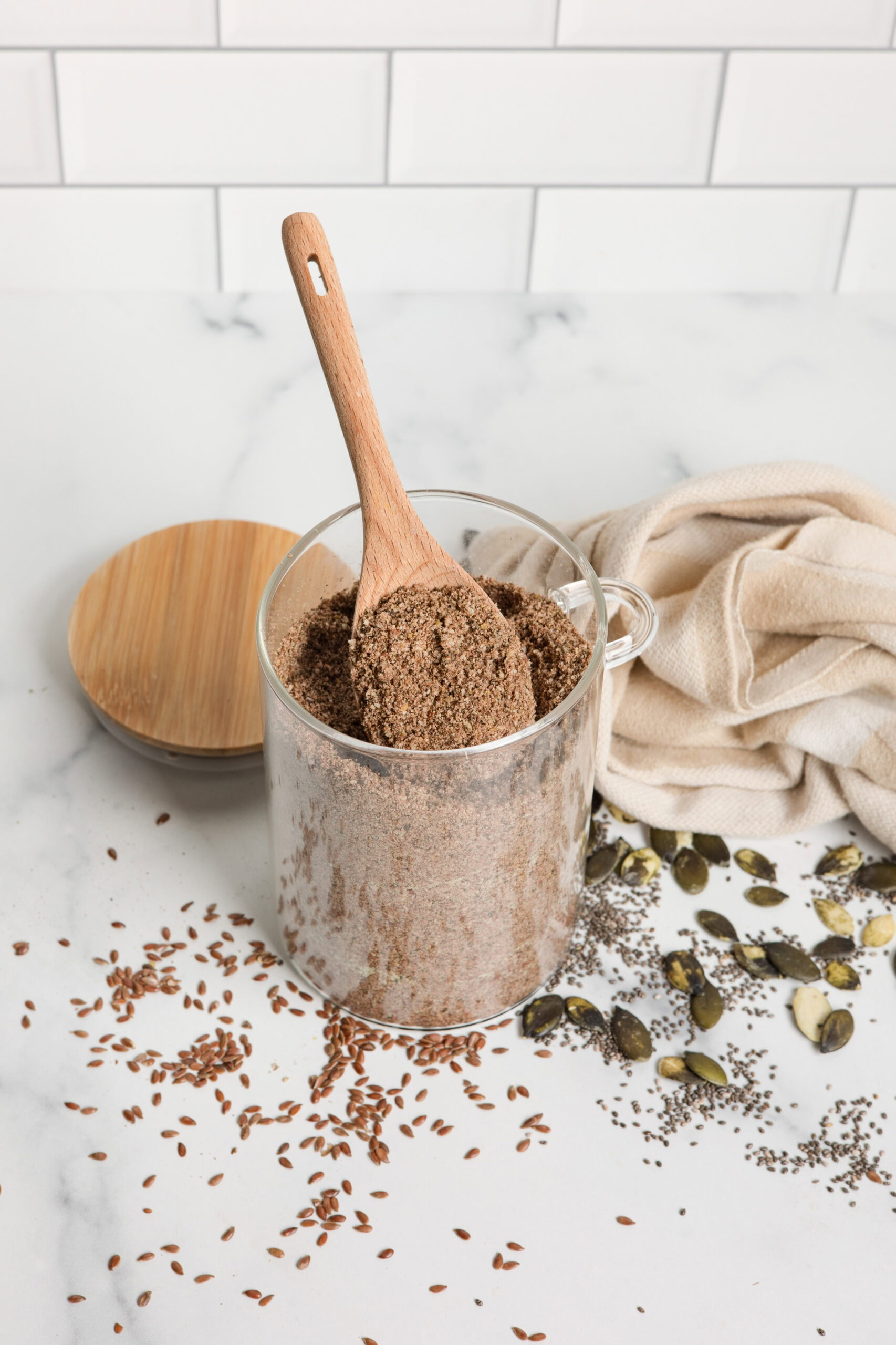 glass jar of homemade protein powder with wood spoon