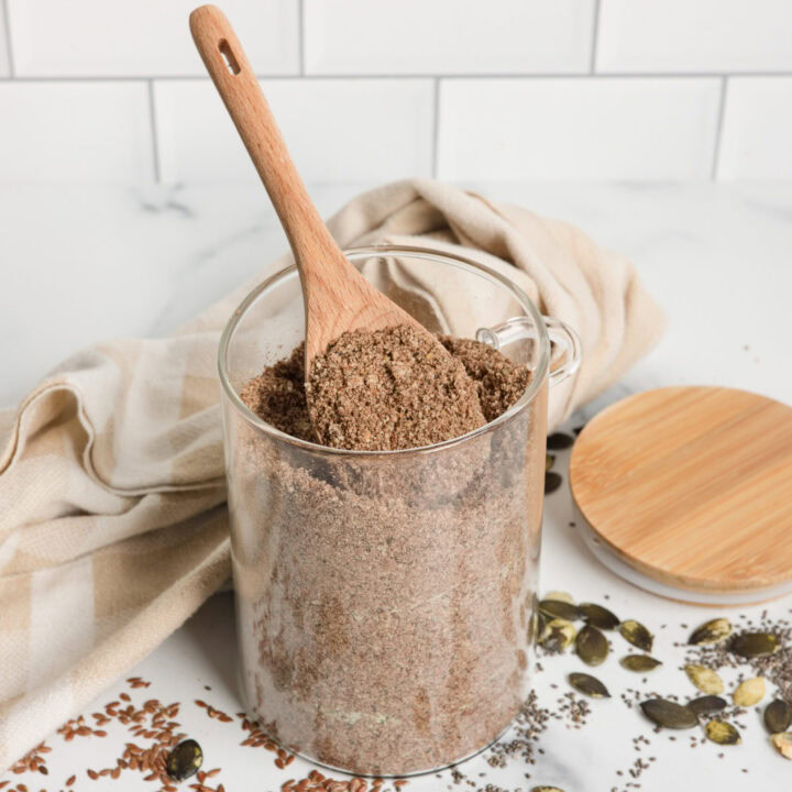 glass jar of homemade protein powder with wood spoon
