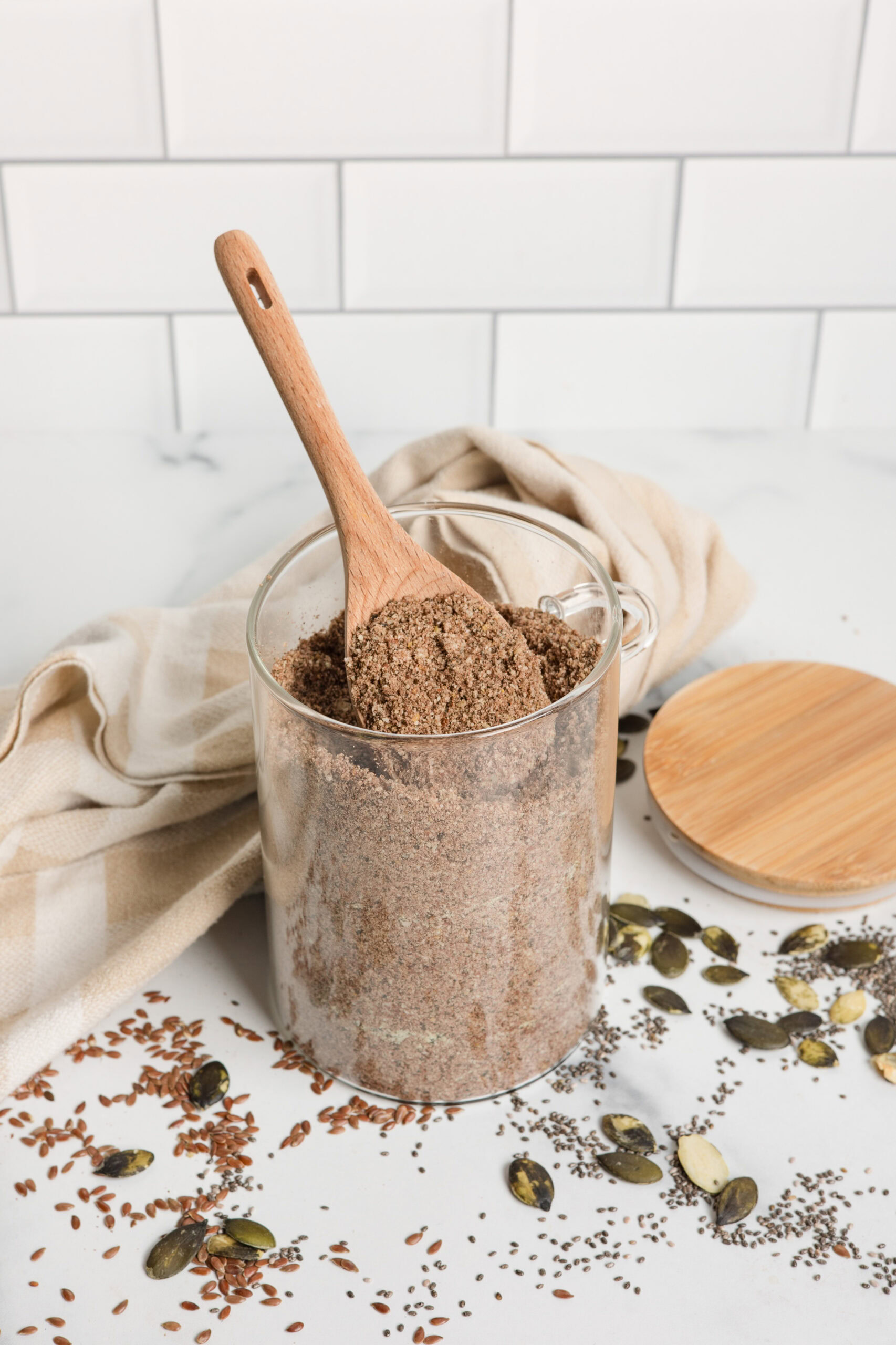 glass jar of homemade protein powder with wood spoon