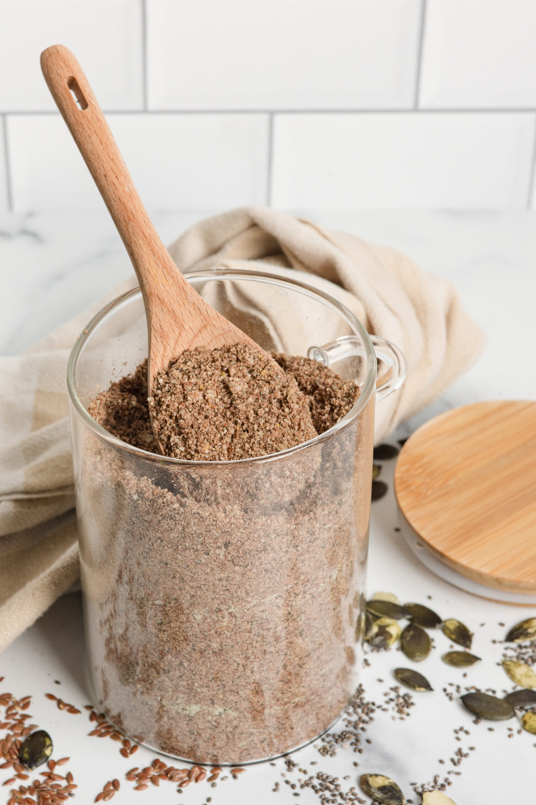 glass jar of homemade protein powder with wood spoon
