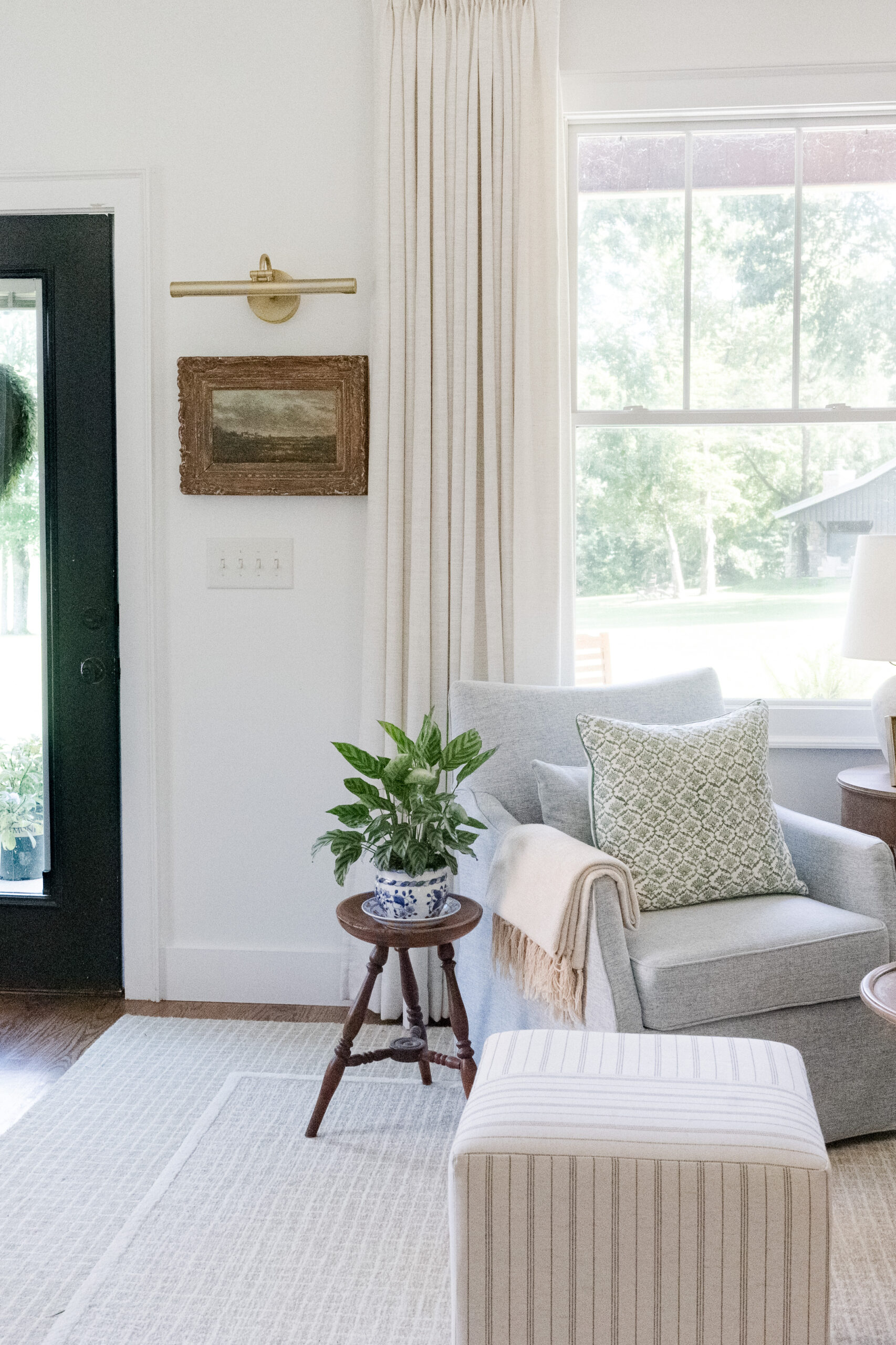 brass picture light above painting in sitting room