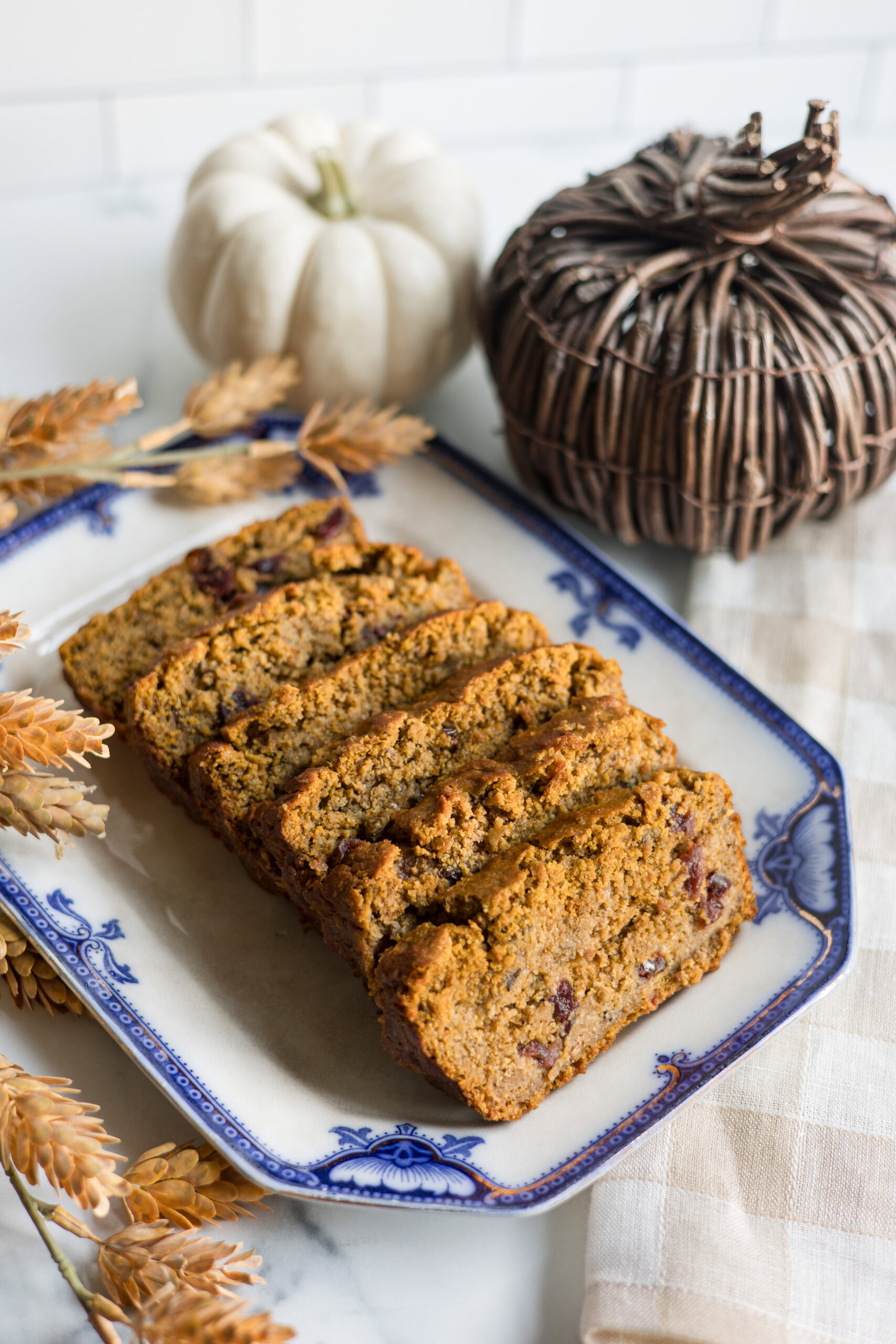 sliced pumpkin cranberry bread on a platter